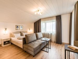 a hotel room with a bed and a couch at Garni Zimmerhofer in Campo Tures
