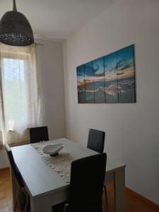 a dining room table with chairs and a painting on the wall at La Quiete appartamento in campagna a Spoleto in Spoleto