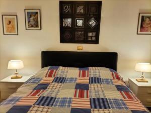 a bedroom with a bed with two night stands and two lamps at La Quiete appartamento in campagna a Spoleto in Spoleto
