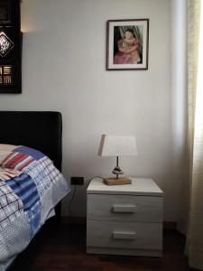 a nightstand with a lamp on it next to a bed at La Quiete appartamento in campagna a Spoleto in Spoleto +18 photos