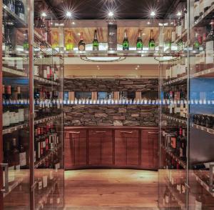 a wine bar with shelves of wine bottles at La Val Hotel & Spa in Breil/Brigels