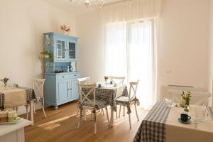 a dining room with a table and chairs and a blue cabinet at Dolce Conero Guest House in Camerano