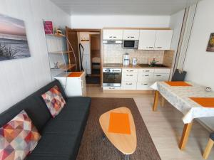 a living room with a black couch and a kitchen at Ferienwohnung Haus Weitblick in Medebach