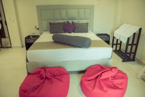 a bedroom with a large bed with two bags on the floor at Mzion Hotel Weligama in Weligama