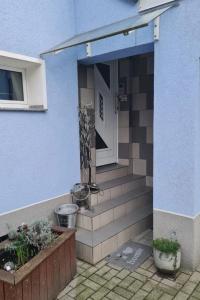 a front door of a blue house with stairs at Schnuckelchen in Marl 2 in Marl +5 photos