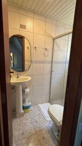 a bathroom with a toilet and a sink and a mirror at Hotel Pousada do Mel in Gramado