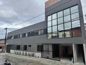 a large gray building with a lot of windows at Duplex Coité in Conceição do Coité