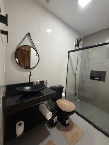 a bathroom with a sink and a toilet and a mirror at Duplex Coité in Conceição do Coité +29 photos