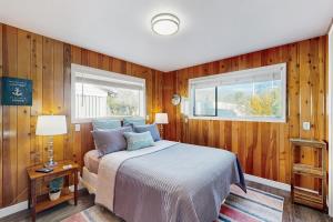 a bedroom with wooden walls and a bed and a window at Ocean View Retreat in Brookings