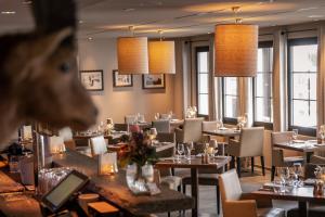 a restaurant with tables and chairs and windows at La Val Hotel & Spa in Breil/Brigels +47 photos