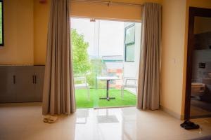 a living room with a large glass door with a table at Mzion Hotel Weligama in Weligama +174 photos