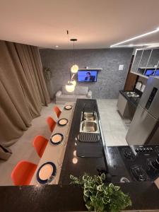 a living room with a kitchen with a stove at Duplex Coité in Conceição do Coité