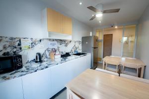 a kitchen with a table and a counter top at Cozypod Rentals in Sagcahan