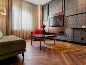 a living room with a red chair and a table at Vértice Sevilla Aljarafe in Bormujos