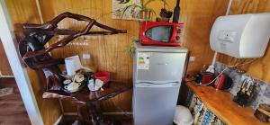 a small kitchen with a refrigerator and a microwave at Cabaña Terraza del Yates in Puerto del Yate
