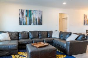 a living room with a brown leather couch at Sunset Blessing - 207 Arias Ct in Dauphin Island