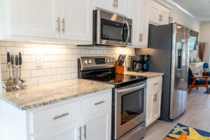 a kitchen with white cabinets and a stove top oven at Sunset Blessing - 207 Arias Ct in Dauphin Island