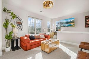 a living room with an orange couch and a table at The Revive Loft with Balcony, Workspace and Bikes in Fort Collins