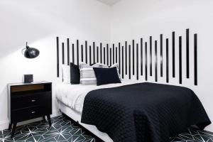 a bedroom with a black and white bed and a nightstand at Hollyhock Suite 409 in Louisville