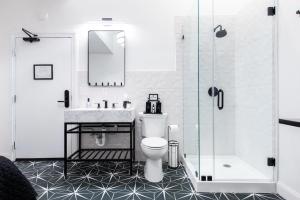 a bathroom with a toilet and a sink and a shower at Hollyhock Suite 409 in Louisville