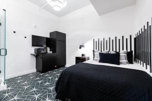 a bedroom with a bed with a black and white comforter at Hollyhock Suite 409 in Louisville