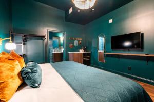a bedroom with a large bed and a flat screen tv at Hollyhock Suite 411 in Louisville
