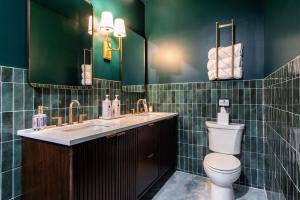 a green bathroom with a toilet and a sink at Hollyhock Suite 411 in Louisville