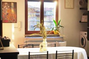 a table with a white vase with a plant on it at QuickHome Villa Il Tiglio in Vigliano Biellese