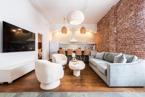 a living room with a couch and a brick wall at Hollyhock Suite 407 in Louisville