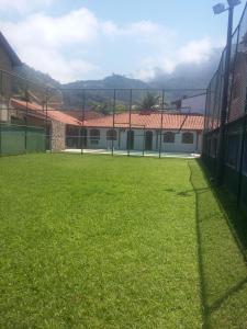 a soccer field with a fence in front of a building at Pousada Recanto de Itacuruçá in Itacuruçá