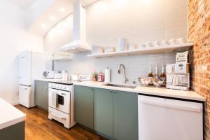 a kitchen with white appliances and a brick wall at Hollyhock Suite 407 in Louisville +19 photos