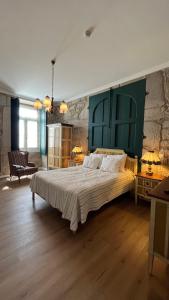 a bedroom with a large bed with a green headboard at Casa da Freiria in Ponte de Lima