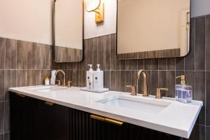 a bathroom with two sinks and two mirrors at Hollyhock Suite 412 in Louisville