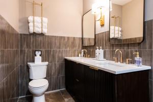 a bathroom with a toilet and a sink and mirrors at Hollyhock Suite 412 in Louisville