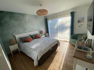 a bedroom with a bed and a couch at La Note Bleue - Chambres d'hôtes in Échillais +33 photos