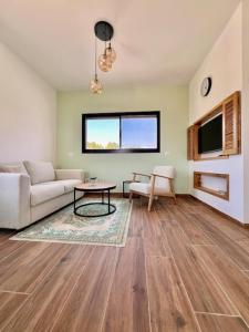 a living room with a couch and a table at The Peleg Tal Unit - היחידה בפלג טל in Dafna