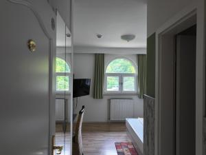 a living room with two windows and a television at Meyerhof Heiligenrode in Stuhr