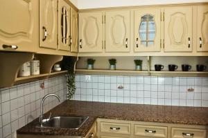 eine Küche mit weißen Schränken und einer Spüle in der Unterkunft maison jamouri in Kríni