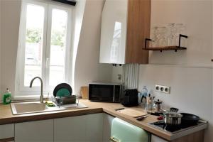 a kitchen with a sink and a microwave at La suite dorée in Étretat