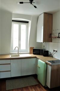 a kitchen with white cabinets and a green refrigerator at La suite dorée in Étretat +7 photos
