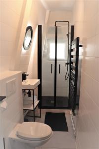 a small bathroom with a toilet and a sink at La suite dorée in Étretat