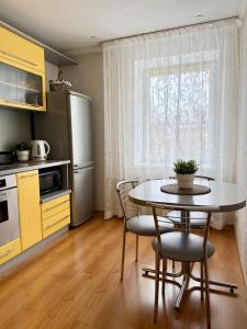 a kitchen with a table and chairs and a window at Center two bedroom apartment in Daugavpils