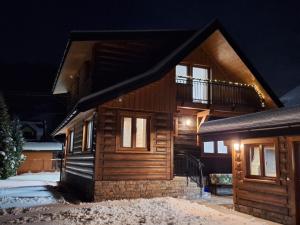 a wooden house at night in the snow at Drevenica Skye Terchová in Terchová