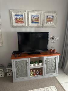 a entertainment center with a flat screen tv on top at Sea Breeze in Mossel Bay
