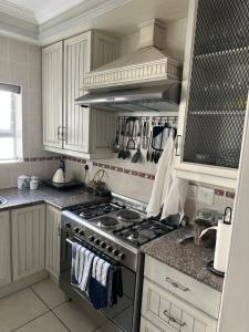 a kitchen with white cabinets and a stove top oven at Sea Breeze in Mossel Bay +28 photos