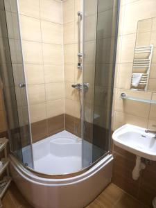 a shower with a glass door next to a sink at Ośrodek Wczasowy Groń Placówka in Białka Tatrzańska +77 photos