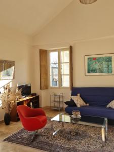 a living room with a blue couch and a red chair at Gite du Bois de Lord in Grandham