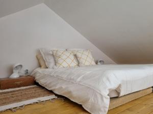 a bedroom with a bed with white sheets and pillows at Gite du Bois de Lord in Grandham