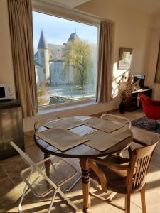 a living room with a table and a large window at Gite du Bois de Lord in Grandham
