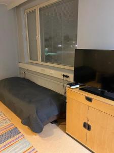 a bedroom with a bed and a flat screen tv at Varastotie 1C in Ylivieska
